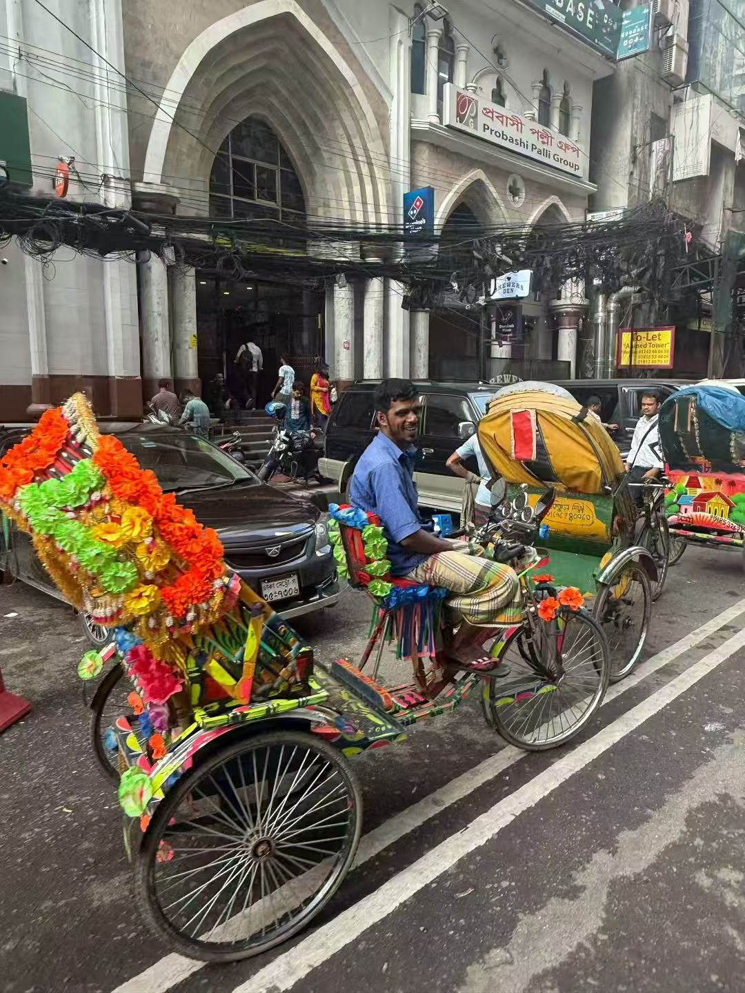 Painted rickshaws on a street in Dhaka.
