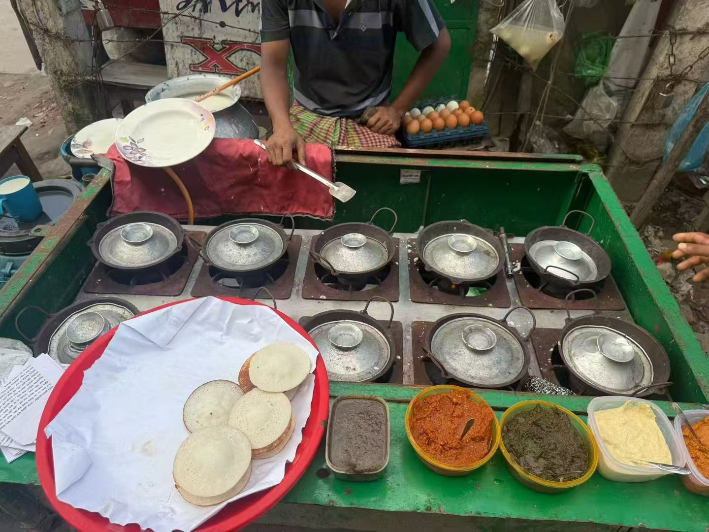 Flatbreads being prepared alongside their accompaniments.