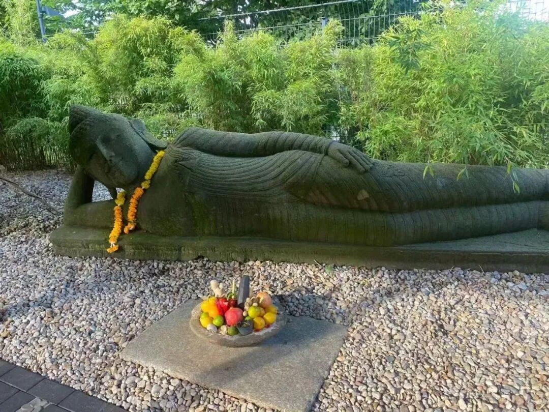 A reclining Buddha figure and greenery in the grounds.